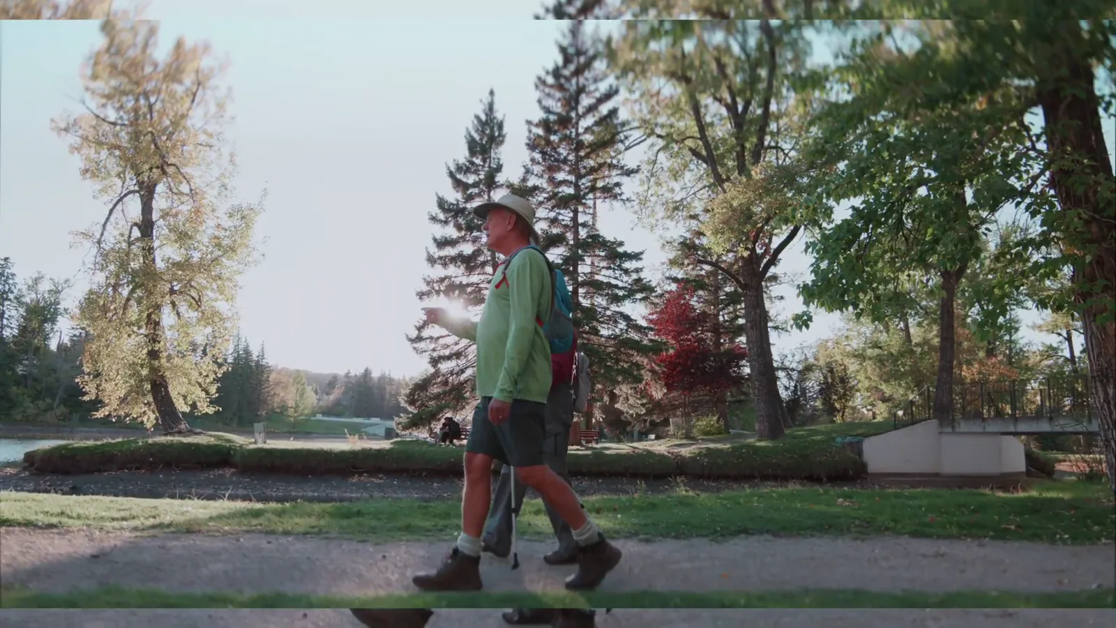 A man walking a park path in early morning light